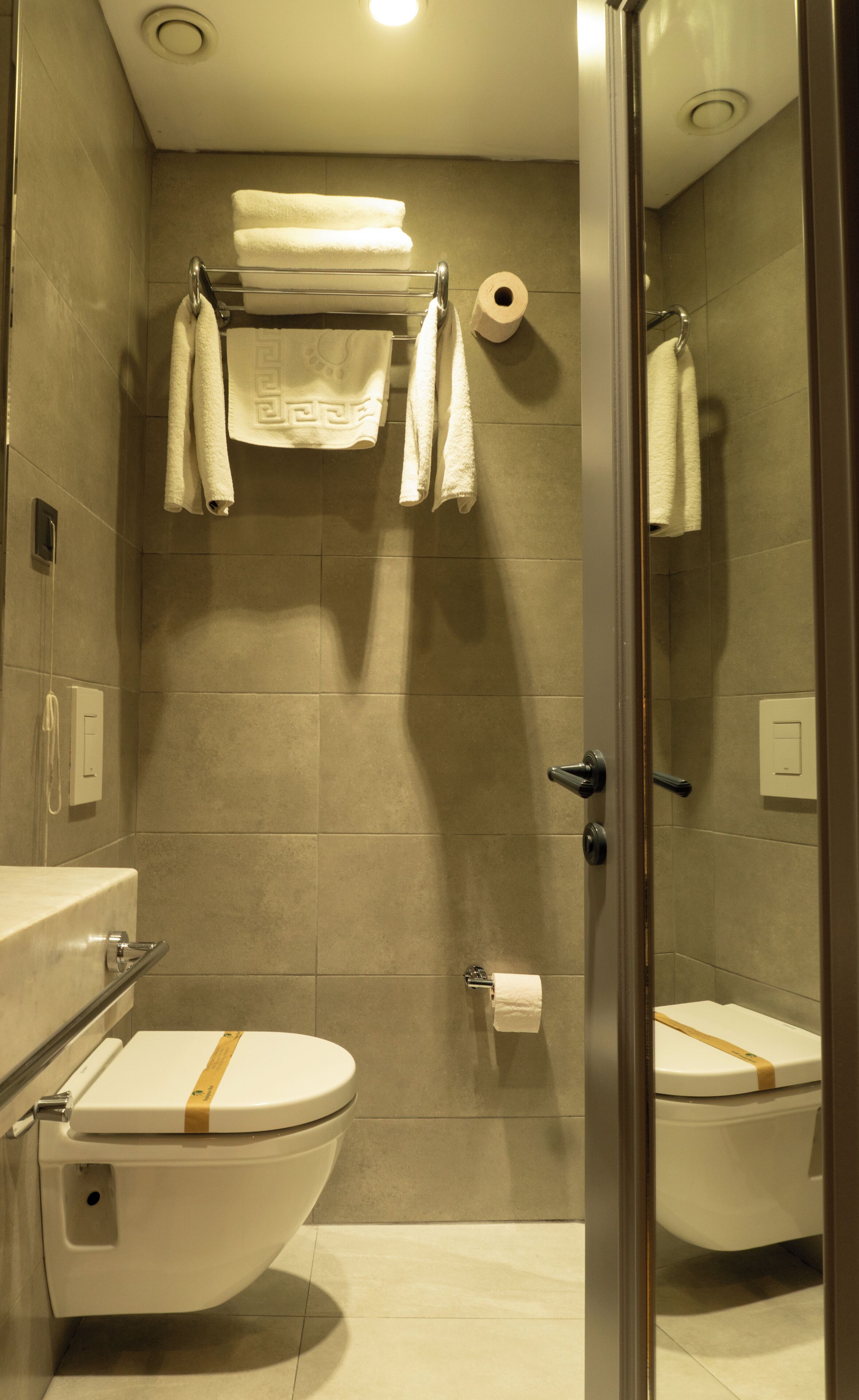 Une salle de bain avec deux toilettes, une douche et un espace de douche vitré.