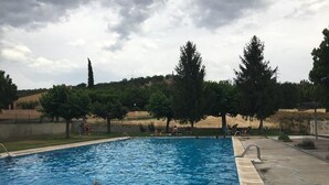 A swimming pool with a clear view of the surrounding landscape, including trees and a distant building. - Tato House -Figuerola d'Orcau- (Figuerola de Orcau)