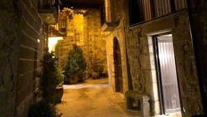 A narrow stone alleyway with a door on the right and a small tree in the center. - Tato House -Figuerola d'Orcau- (Figuerola de Orcau)