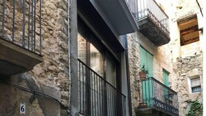 A stone building with a balcony, a door, and a window. - Tato House -Figuerola d'Orcau- (Figuerola de Orcau)