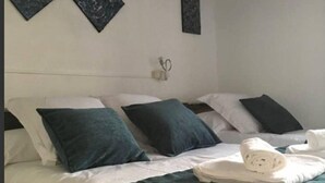 A bedroom with a bed, pillows, a ceiling fan, and artwork on the walls. - Tato House -Figuerola d'Orcau- (Figuerola de Orcau)