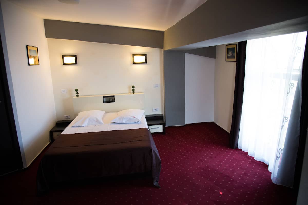 Eenvoudige eenpersoonskamer | Een minibar, een kluis op de kamer, een bureau, verduisterende gordijnen