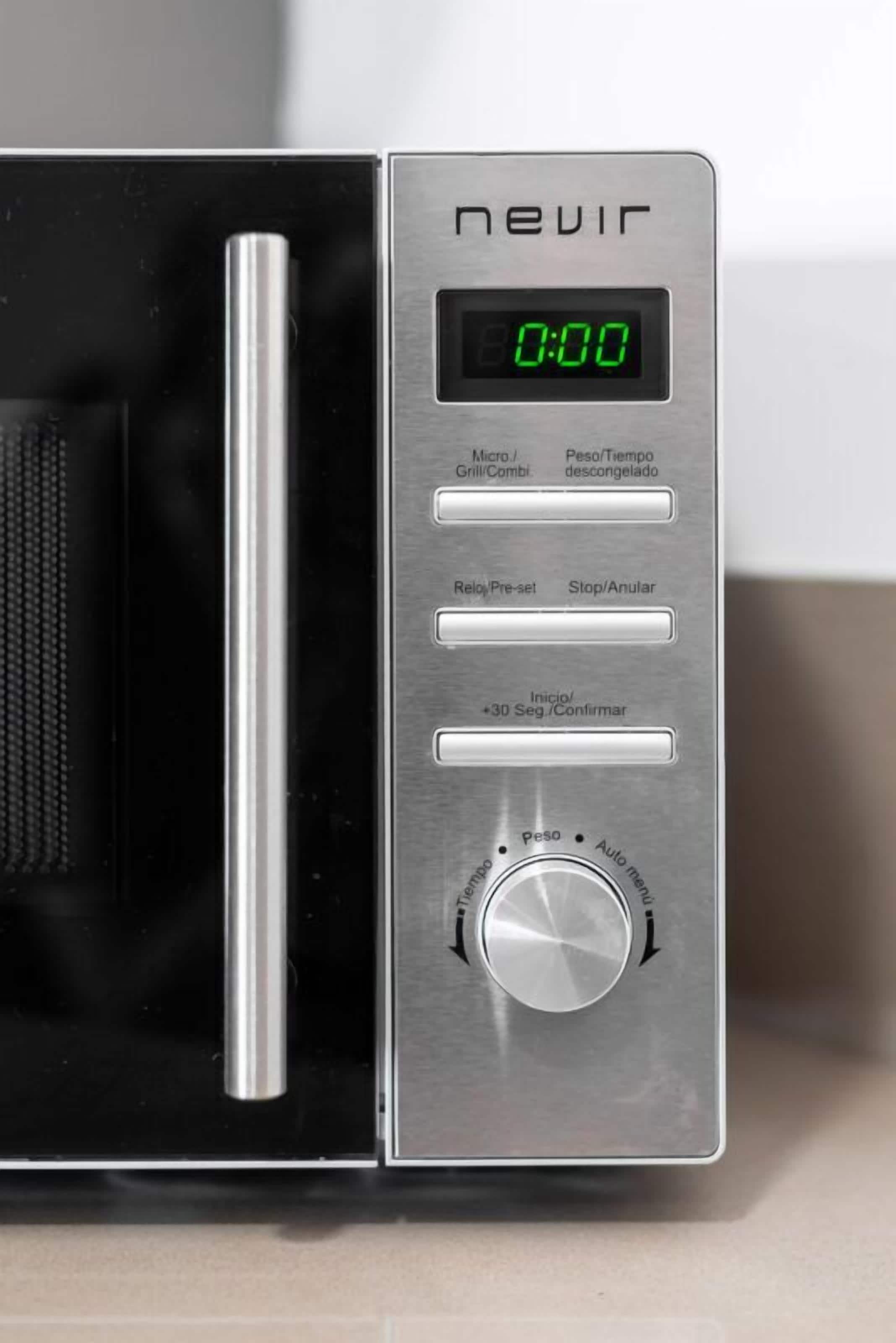 Un microondas con pantalla digital, botones de control y un mando giratorio para el temporizador.