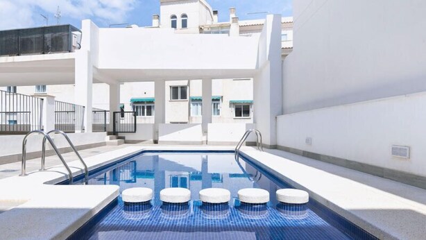 A swimming pool with steps leading into it, surrounded by white walls and a clear sky. - Salamandra Altea 17 By Vero (Altea)