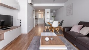 A modern living room with a flat-screen TV, a dark brown sofa, and a coffee table with decorative items. - Salamandra Altea 17 By Vero (Altea)