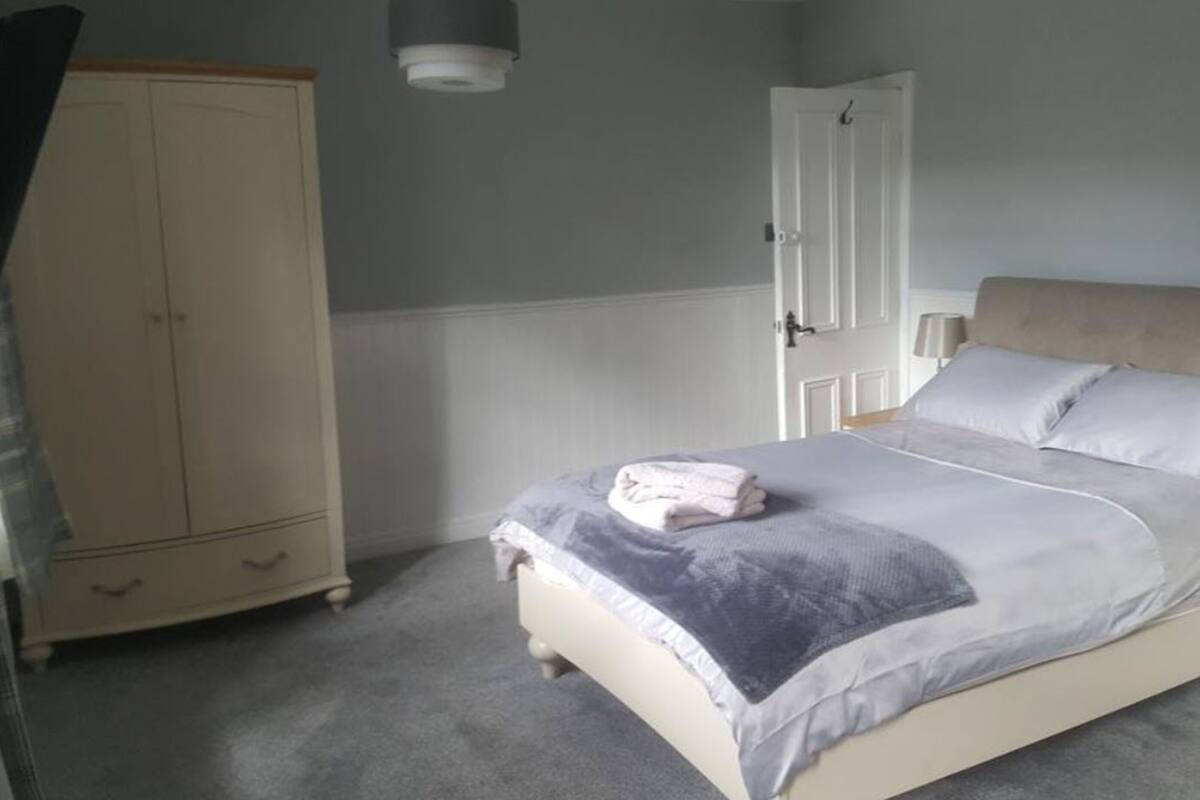 A bedroom with a bed, a wardrobe, and a door.