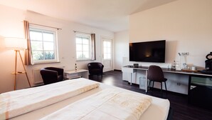 A hotel room with two beds, a desk, a chair, a TV, and a window. - Hotel Garni Rank (Bad Berka)