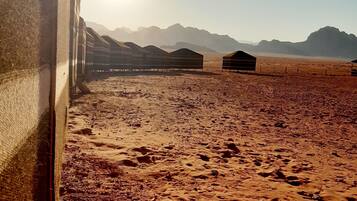 A desert landscape with a clear sky and mountains in the distance.