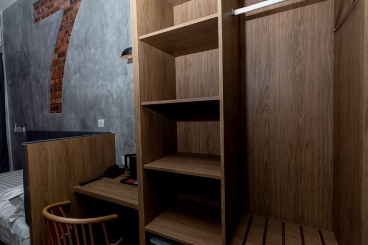 A room with a bed, a desk, and a wardrobe.