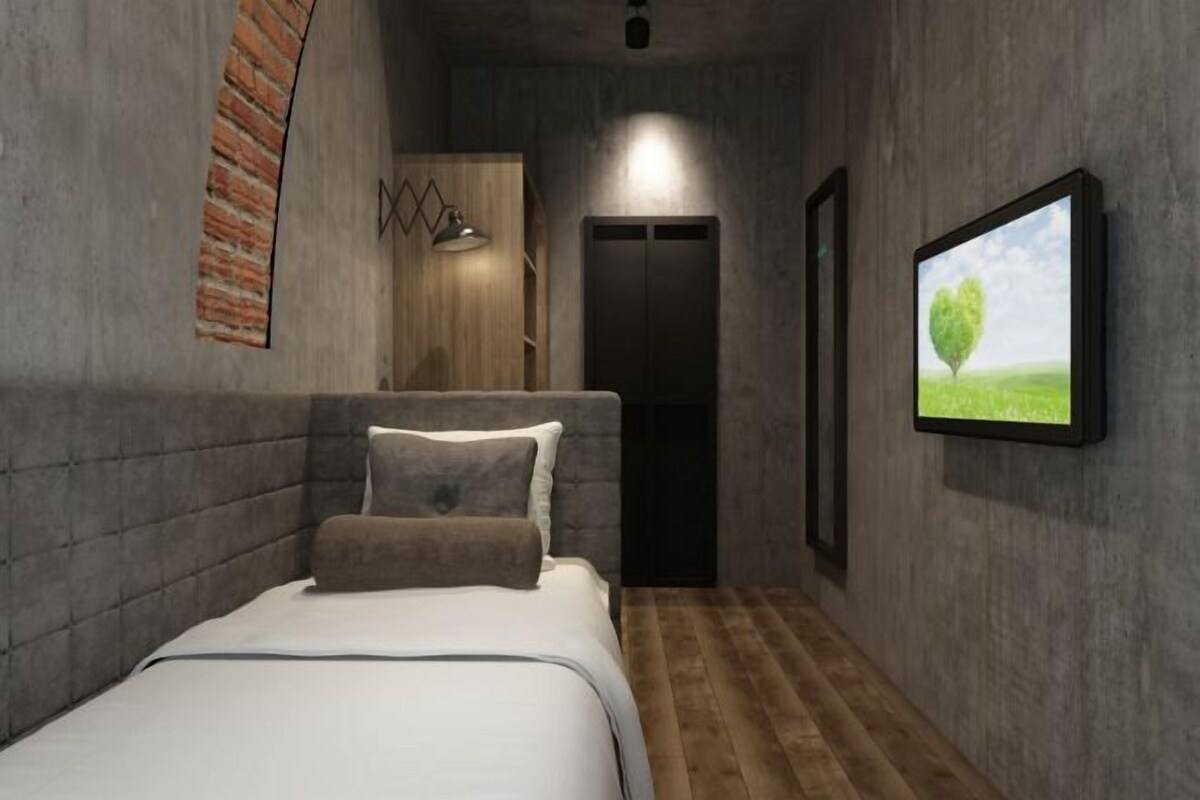 A bedroom with a bed, a wardrobe, a door, and a framed picture on the wall.