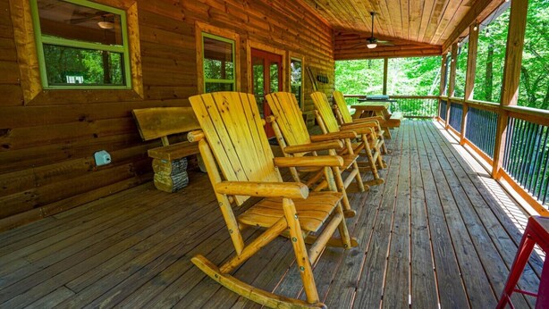 A wooden cabin with a porch featuring rocking chairs and a ceiling fan. - Foothills Family Retreat - Hot Tub and Fire Pit (Dahlonega)
