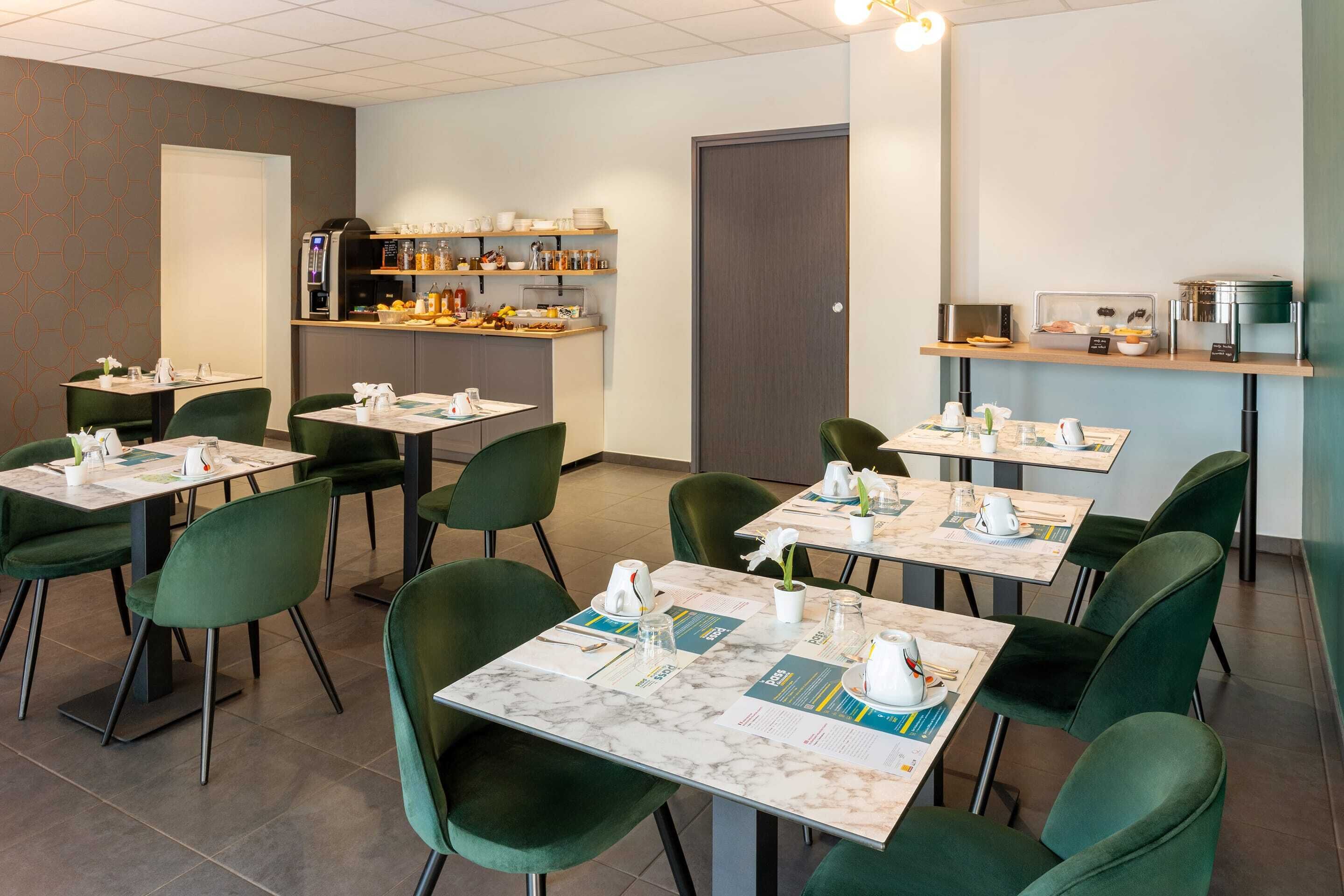 A restaurant with green chairs and tables, a coffee machine, and a counter with food items.