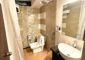 Un baño con inodoro, lavamanos y ducha.