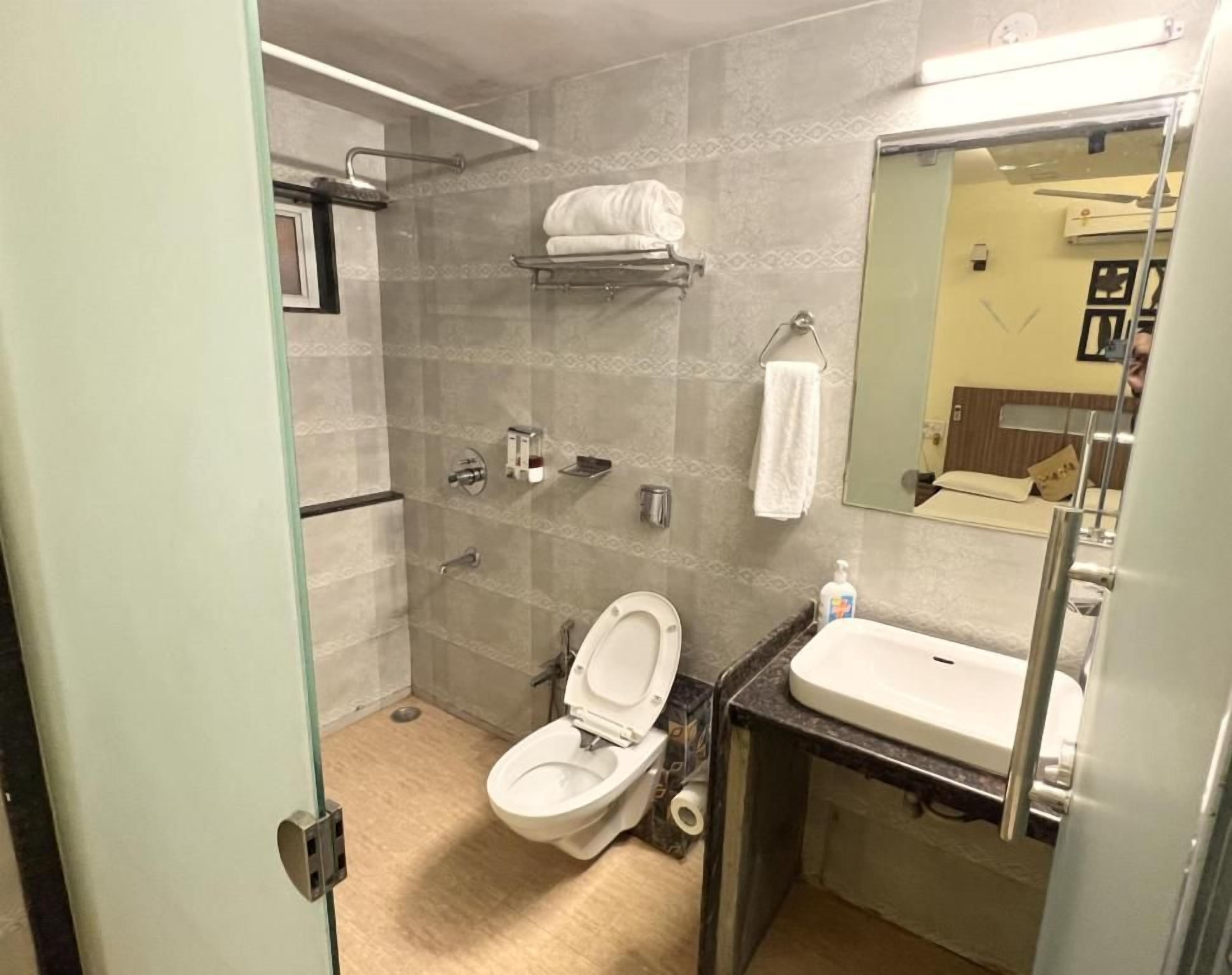 A bathroom with a toilet, sink, and shower area.