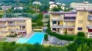 A residential area with multiple two-story buildings, a swimming pool, and lush greenery. - Apartment Enchanting Lake View, convenient to the Center and the Beaches (Malcesine)