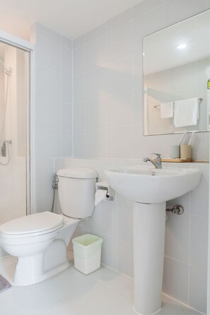 A bathroom with a toilet, sink, and shower.