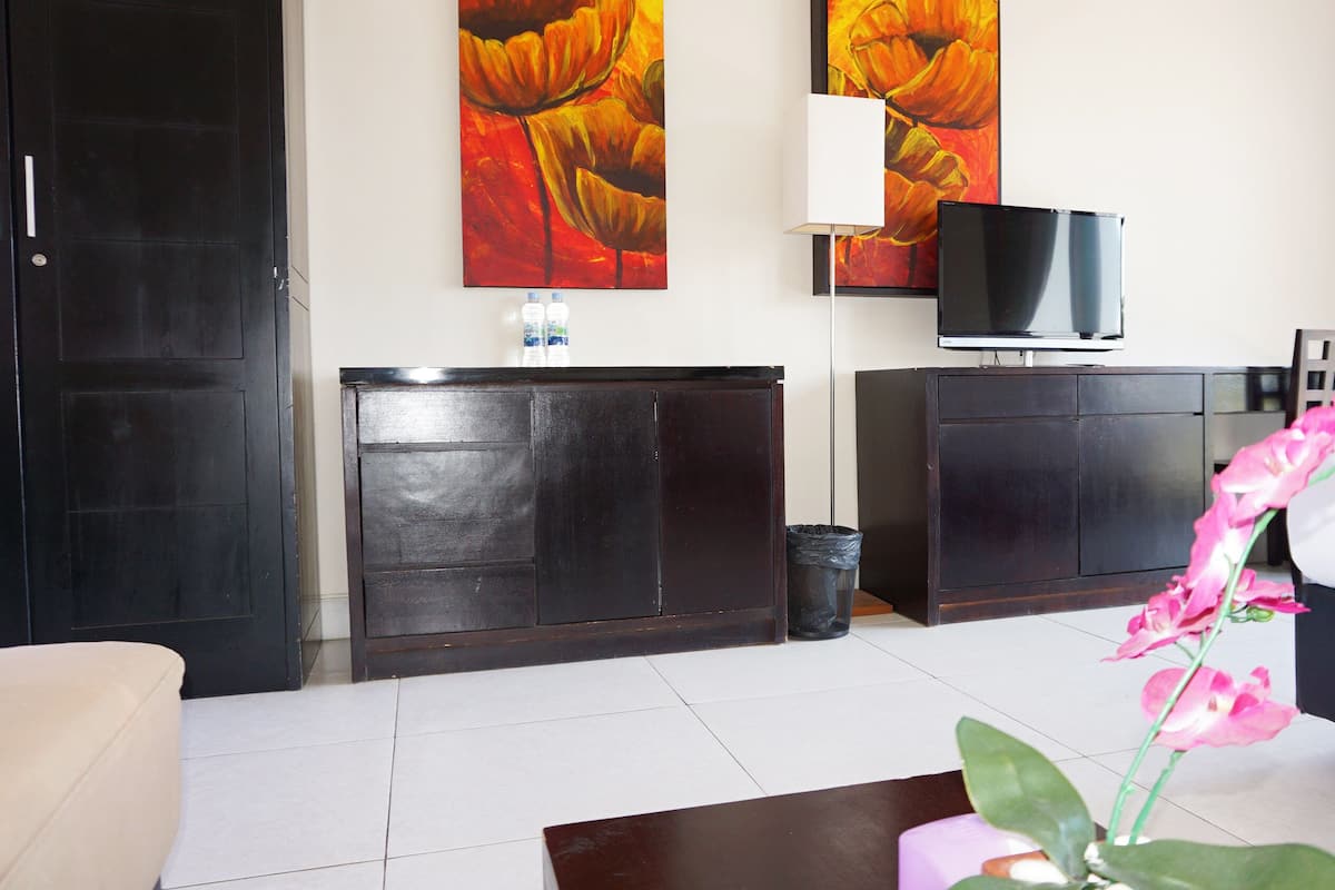 A living room with a sofa, a coffee table, a TV, and a cabinet.