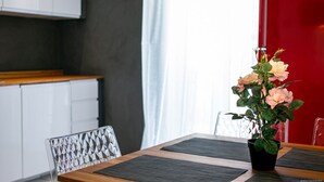Un espace repas moderne avec une table en bois, des chaises transparentes et une plante en pot.