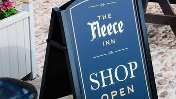 A signboard for The Fleece Inn indicating the shop is open.
