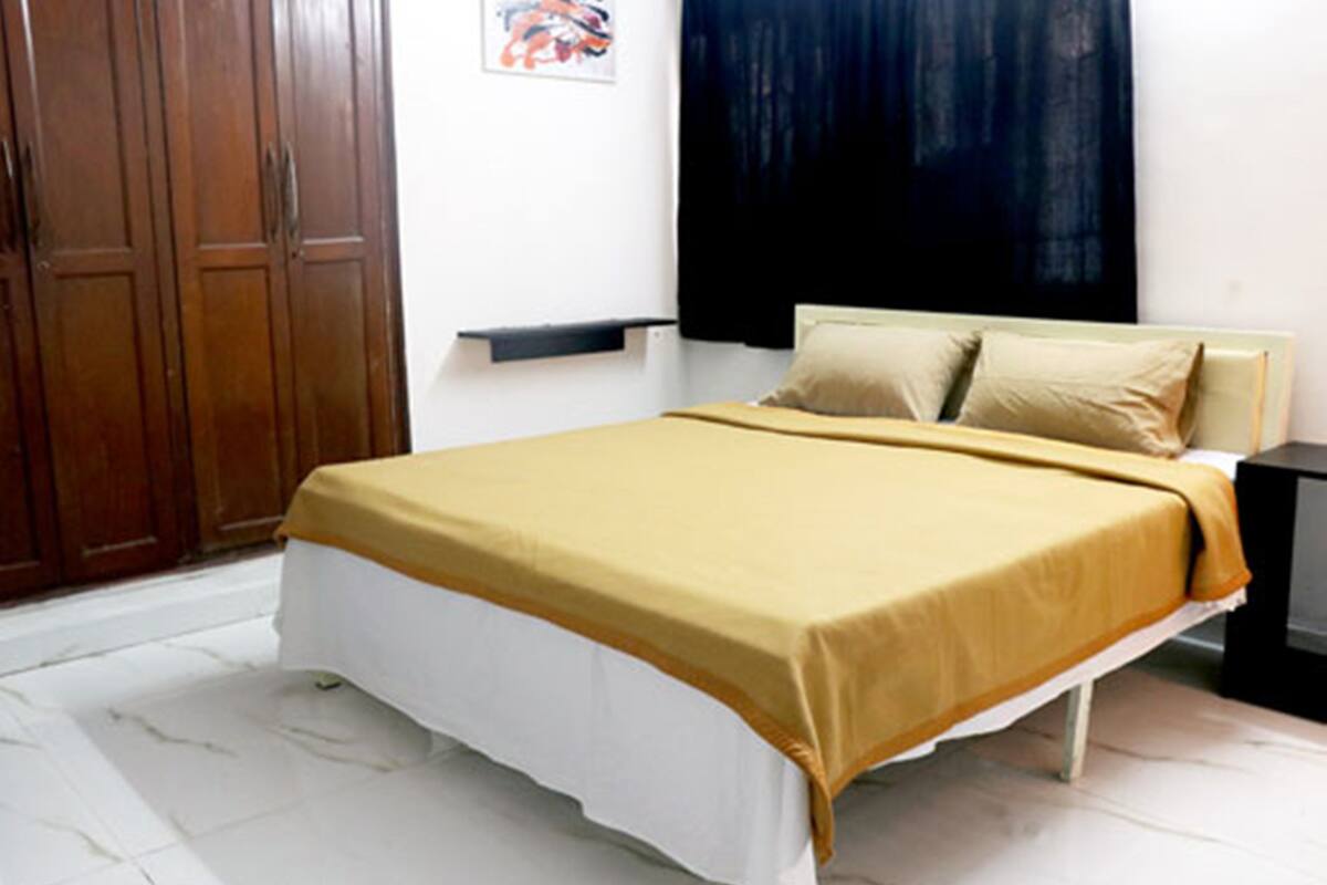 Un dormitorio con cama, armario de madera y un cuadro en la pared.