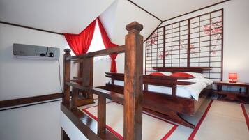 Una camera da letto tradizionale in stile giapponese, con un letto di legno, tatami, un sipario rosso e bianco e un paravento shoji con fiori di ciliegio.