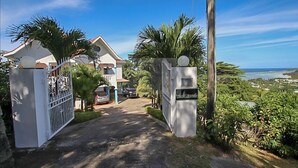 Une entrée fermée par un portail donnant accès à une propriété avec vue sur l’océan.