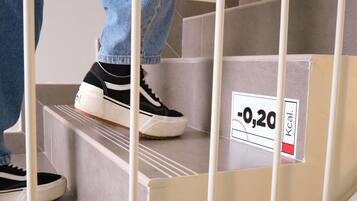 A person ascending a staircase with a sign indicating a caloric value of -0.20.