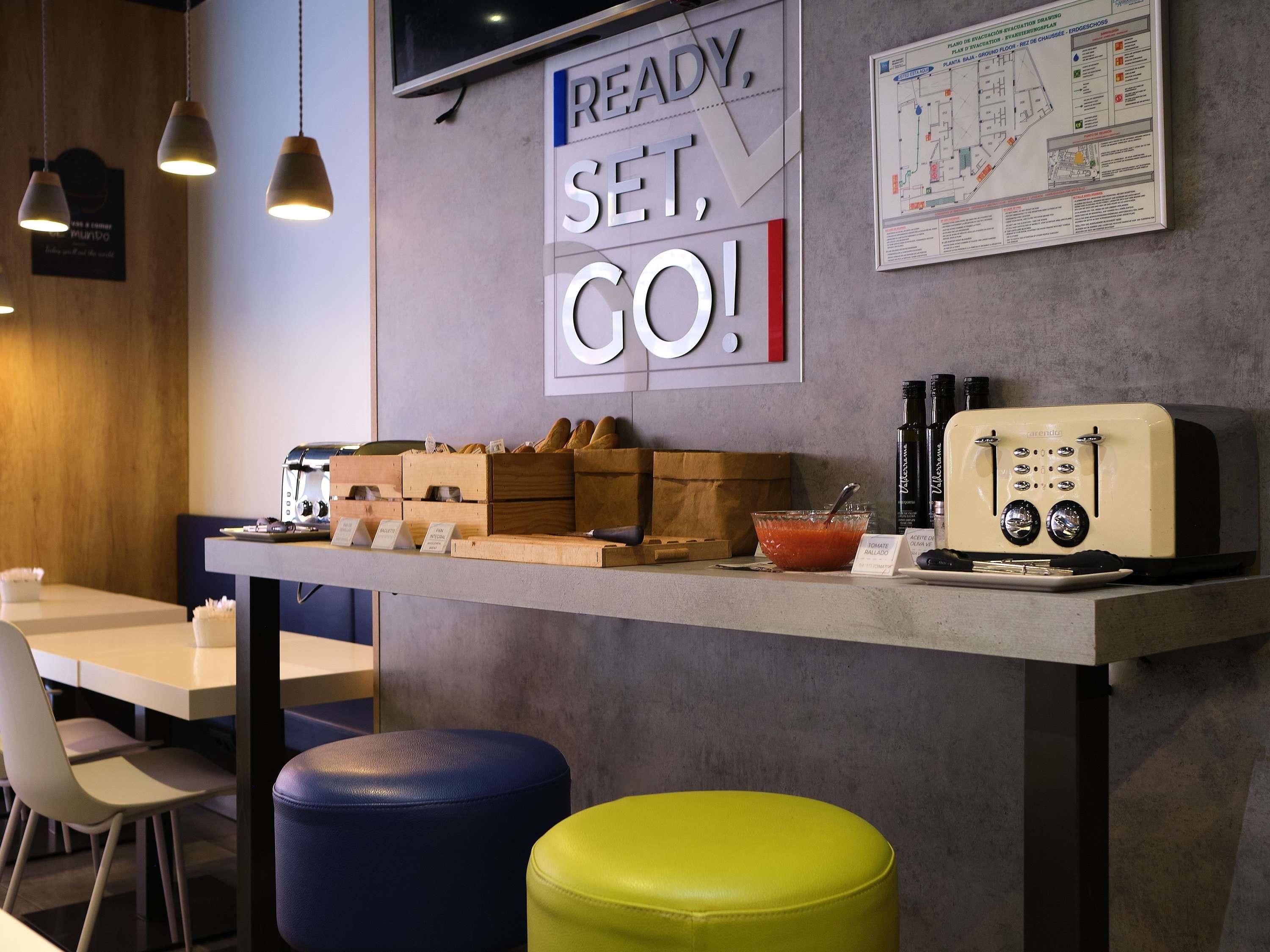 A modern cafe with a counter displaying bread, condiments, and a vintage toaster.
