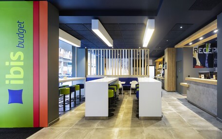 A modern interior with a reception desk, seating area, and a view of the outside.