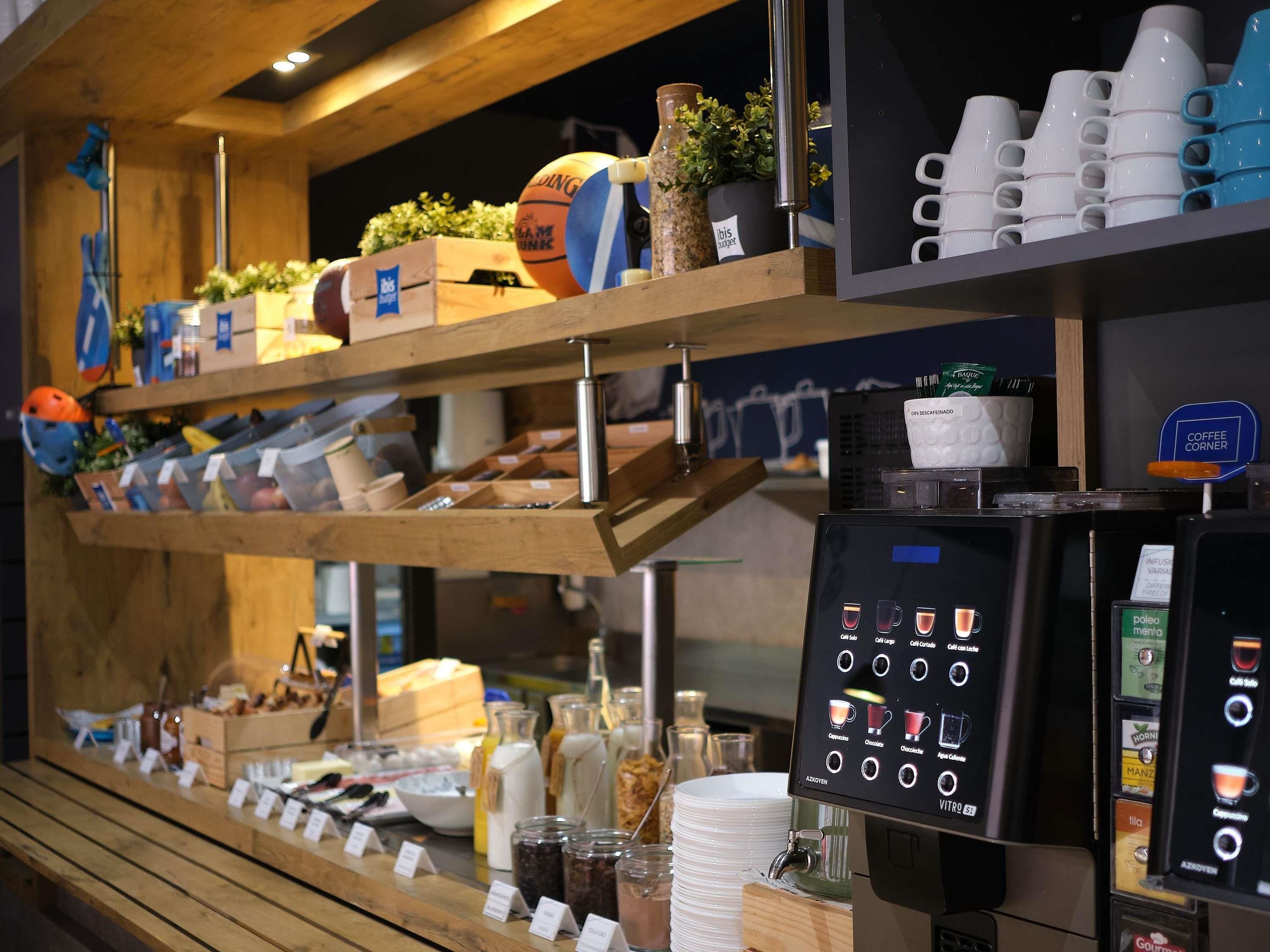 A coffee station with a coffee machine, cups, and various coffee pods.