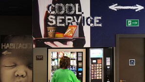 A person in a green shirt interacting with a vending machine in a hotel lobby. - ibis budget Bilbao City (Bilbao)