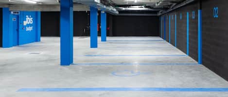 Een parkeergarage met blauwe pilaren, genummerde parkeerplaatsen en een symbool voor rolstoeltoegankelijkheid.