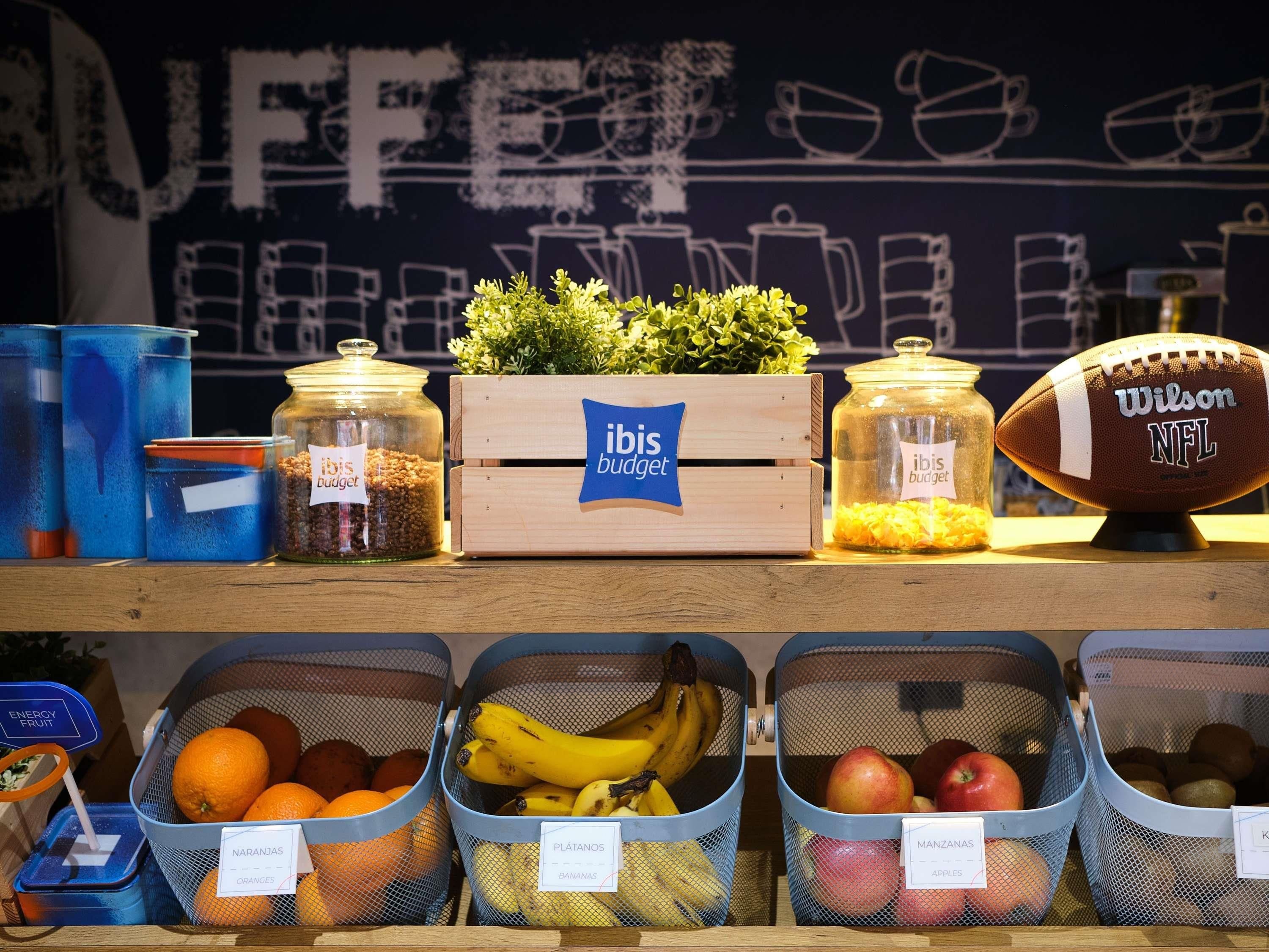 Una estantería con diversos alimentos y recipientes que muestran la etiqueta 'ibis budget'.