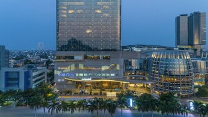 Un hotel moderno con una fachada de vidrio destacada y una estructura de vidrio curva singular.