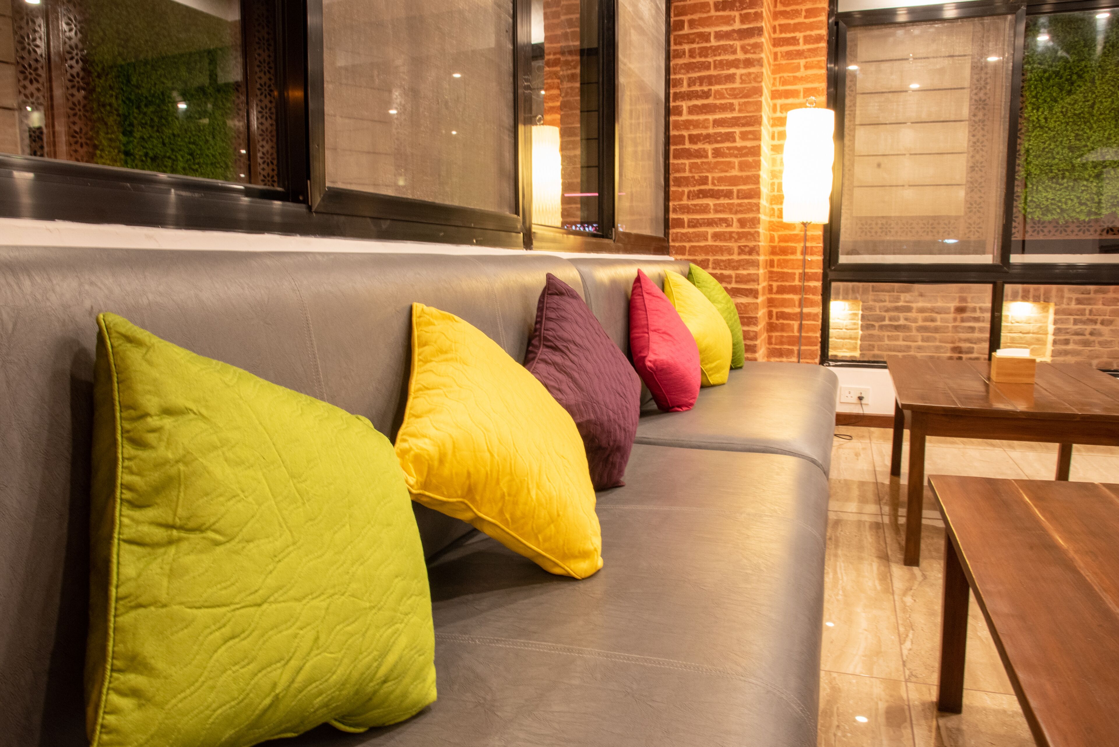 A seating area with a cushioned bench and colorful pillows.