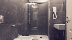 Une salle de bain moderne avec une douche à parois de verre, une baignoire sur pieds et un lavabo.