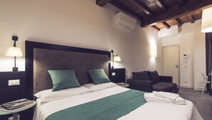 Une chambre d’hôtel équipée d’un lit, de tables de chevet, d’une lampe de lecture, d’une chaise et d’un appareil de climatisation.