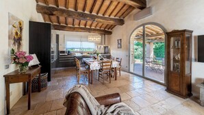 Un espacio habitable amplio con una mesa de comedor, un sofá y una cocina al fondo.
