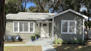 A two-story house with a front porch, a bench, and potted plants. - Posh spacious pool house in the Heights. (Tampa)