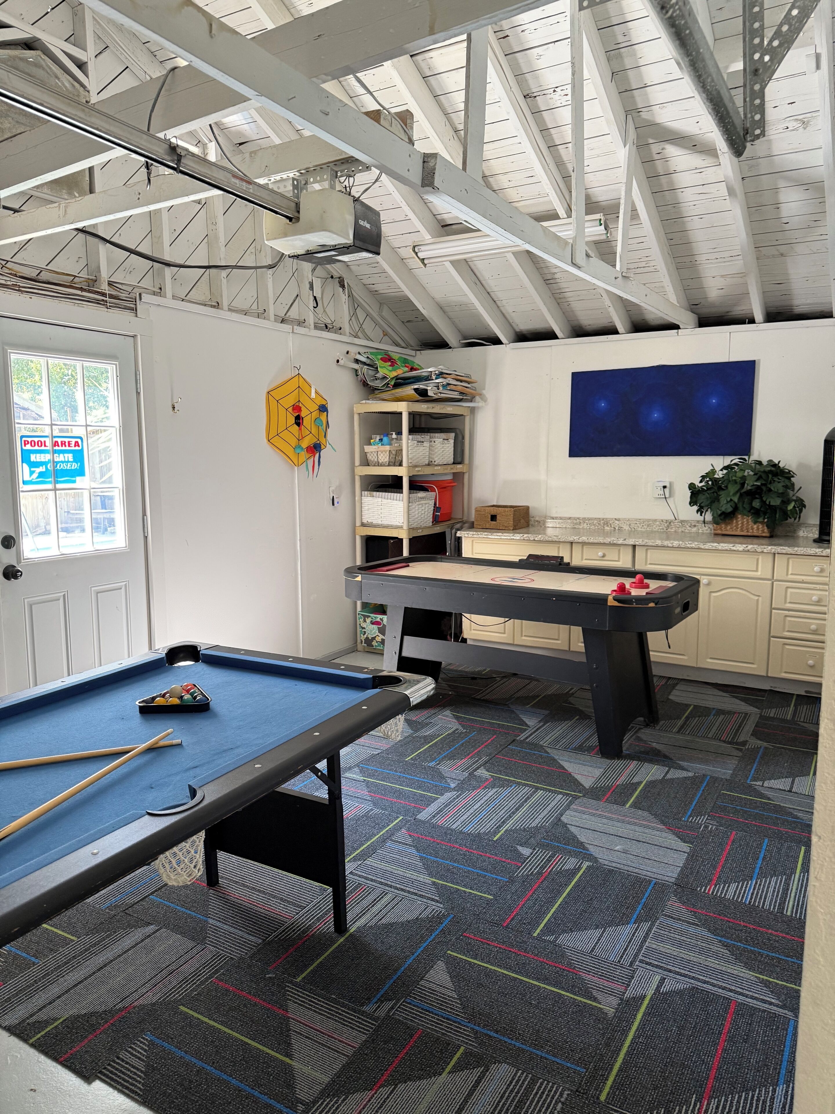 Ein Billardtisch mit Spielzeugspind, Queue und einem Tisch mit gemustertem Teppich.