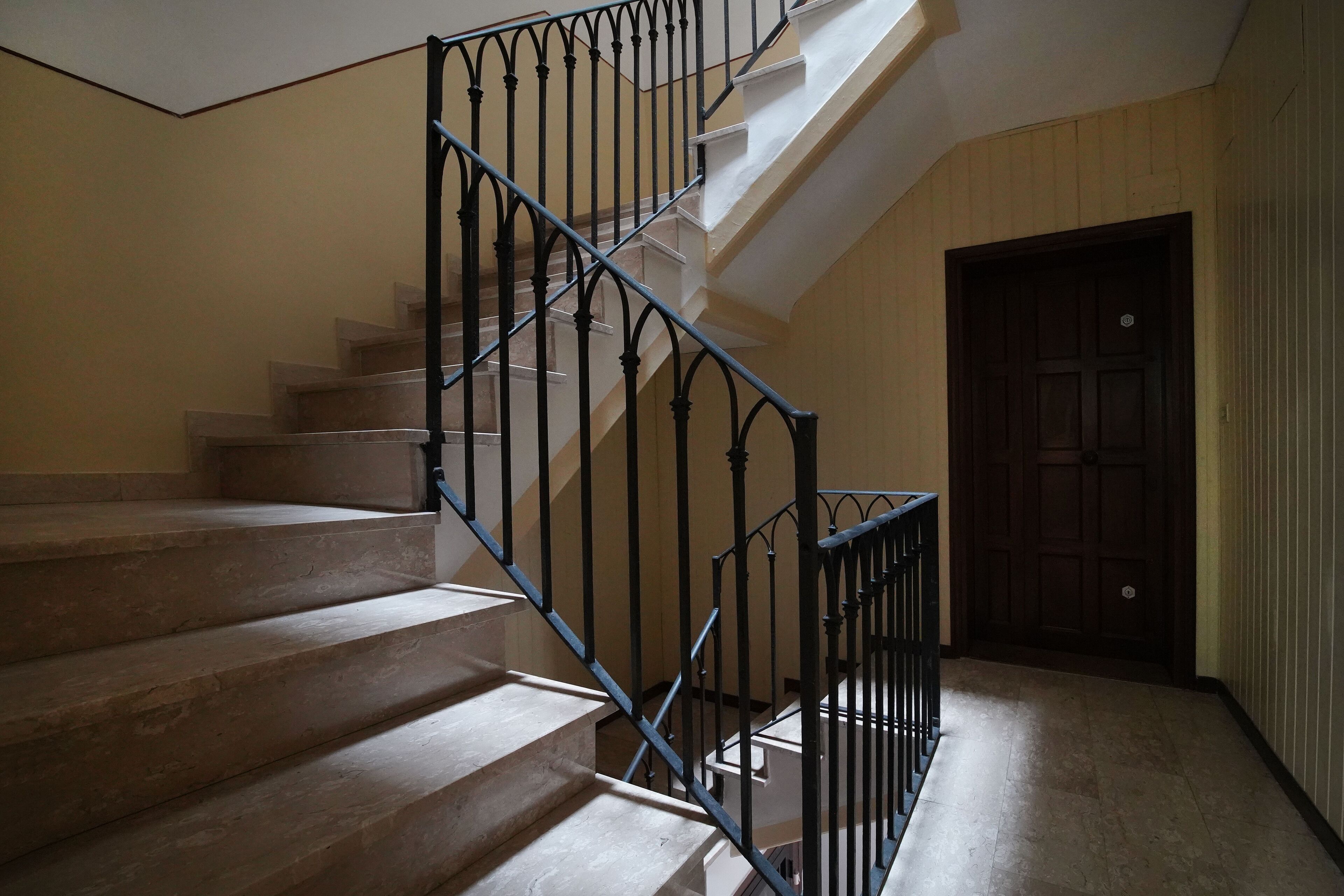 A staircase with a metal railing leading to a landing.