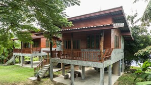 A wooden house with a balcony and a concrete foundation.