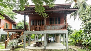 A wooden house with a balcony and a staircase leading to a second floor.