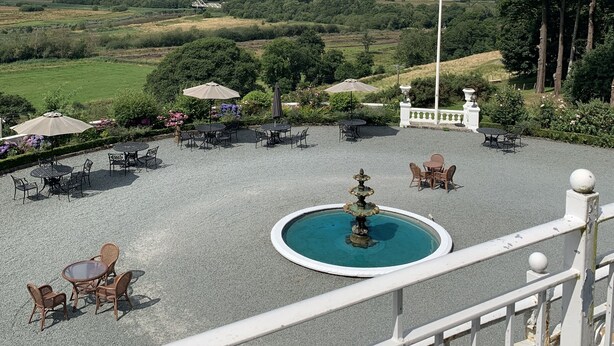 A courtyard with outdoor seating, a fountain, and a flagpole. - Plas Maenan Country House (Llanrwst)