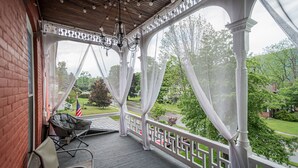 Une véranda donnant sur un jardin et une rue.