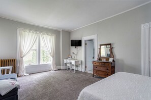 Relax in a spacious room with a large window, comfortable bed, and a desk for work.