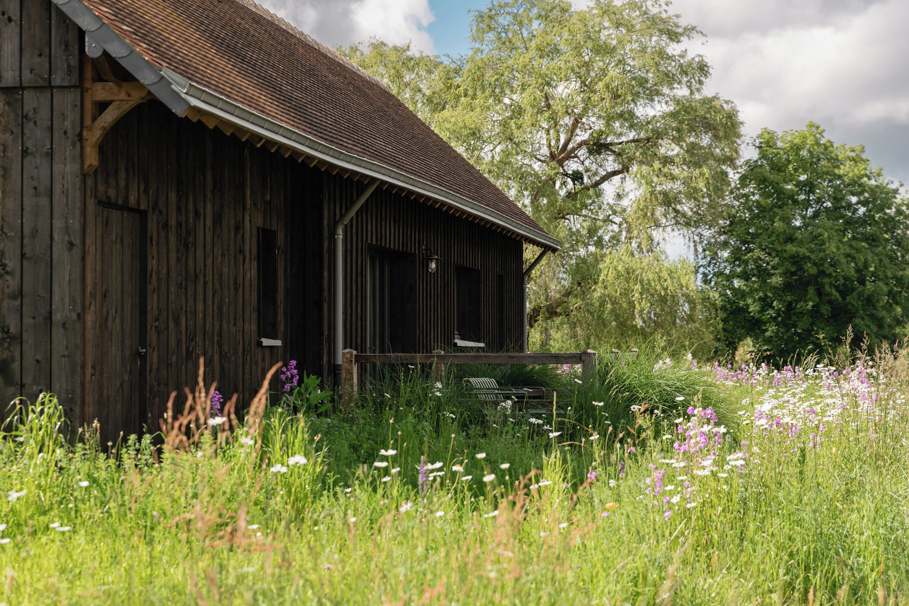 Un bâtiment rustique en bois, doté d’un toit en pente et d’un porche.