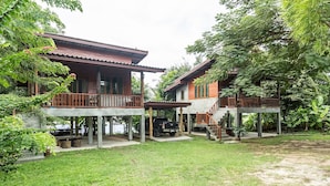 Ein zweistöckiges Holzhaus mit Balkon und überdachter Veranda, ein Lastwagen auf der Einfahrt.