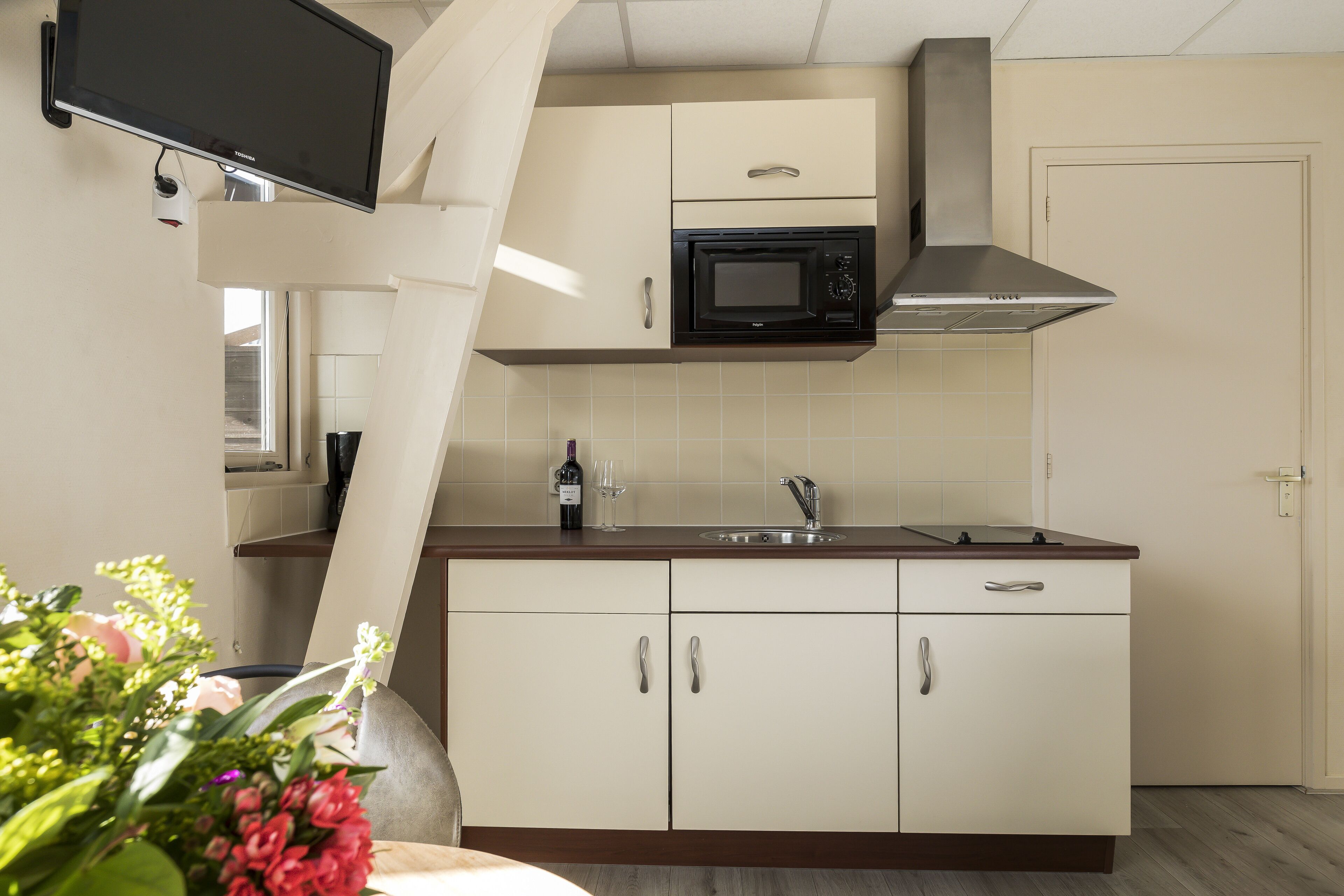 A kitchen with a microwave, sink, and cabinets.