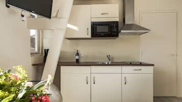 A kitchen with a microwave, sink, and cabinets.